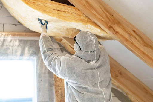 Installing vapor barrier in ceiling spaces.